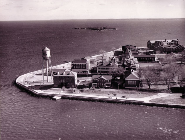 <p>Aerial view of the Hospital Area, looking east, November 1961. Along the shoreline from the left are the Water Tower (Building 45), a multi-family NCO Quarters (Building 44), and the Hospital Sergeants&#39; Quarters (Building 43).</p>