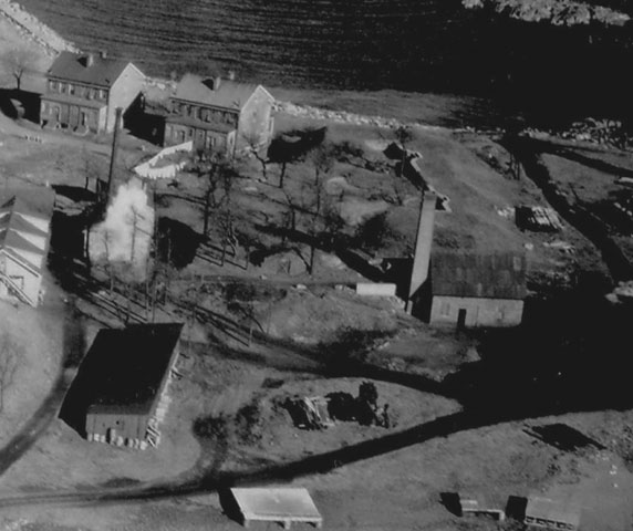 <p>Aerial view of Battery Practice and vicinity, January 1932. Concrete retaining wall and earth parapet are visible behind tall chimney at center right.</p>