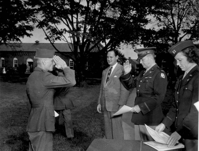 <p>A soldier salutes Colonel Bernard Lentz (center right), Fort Slocum's commanding officer, 1945. The occasion is a graduation exercise for the honor battalion of the Second Service Command&#39;s Rehabilitation Center, which operated at Fort Slocum from late 1944 until mid-1946. The civilian to the left of Col. Lentz is Stanley Church, New Rochelle&#39;s mayor. Capt. Eunity Frances Elderdice stands to Col. Lentz&#39;s right.</p>