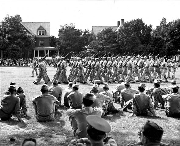<p>Marching in formation on the Parade Ground during a graduation ceremony. Looking west at Officers&#39; Row (Buildings 9 and 10), September 1942.</p>