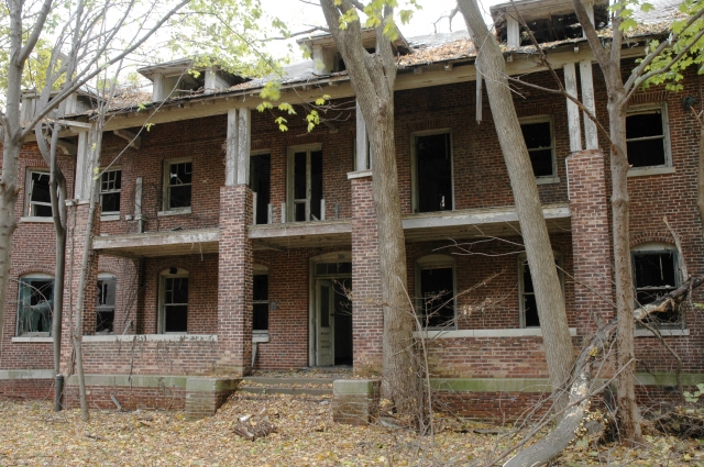 <p><strong>Craftsman-influenced Colonial Revival, details</strong>: Porch with tall brick piers and square wood columns. Officers&#39; Quarters (Building 12), view west, November 2005.</p>