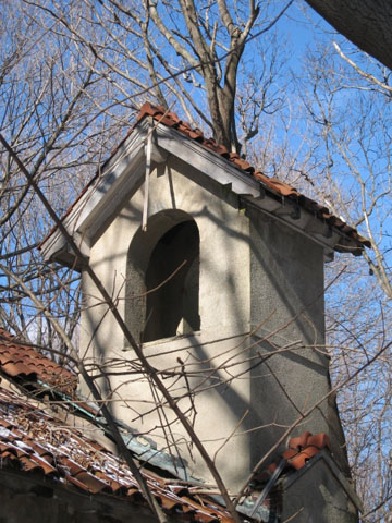 <p><strong>Mission, details</strong>: Bell tower with arched opening, red tile roof, and exposed scrollwork rafter tails. Chapel (Building 108), view northwest, January 2007.</p>