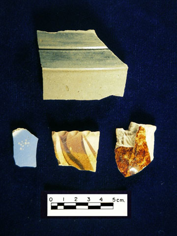 <p>Sherds of several types of 19th-century pottery found during the 2005-2006 archeological survey of Davids Island, including gray salt-glazed stoneware (top) and pearlware, redware with flat slip-trailing, and Rockingham-type yellowware (bottom, left to right).</p>