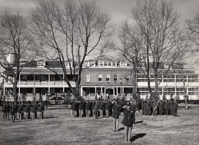 <p>The staff and students of the Army Chaplain School at Fort Slocum, under the command of Chaplain Col. Edward Donahue, in front of the former Post Hospital, then in use as the school headquarters, 1956.</p>