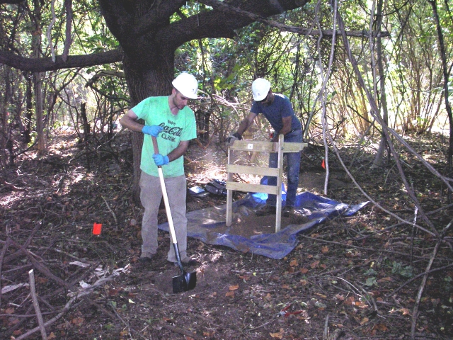 <p>Archeologists excavating a shovel test near the remnants of Building 120 in the Defense and Support Area, September 2005.</p>