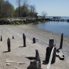 <p>Section of seawall (left) completed about 1908 between Freight Dock (pilings in foreground) and Passenger Pier (at right in water), southwestern shore of Davids Island, looking southeast, April 2006.</p>