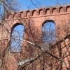 <p><strong>Romanesque Revival, detail</strong>: Round arch window openings and two styles of brickwork cornices. Tower and east wing of Barracks (Building 69), view northwest, January 2007.</p>